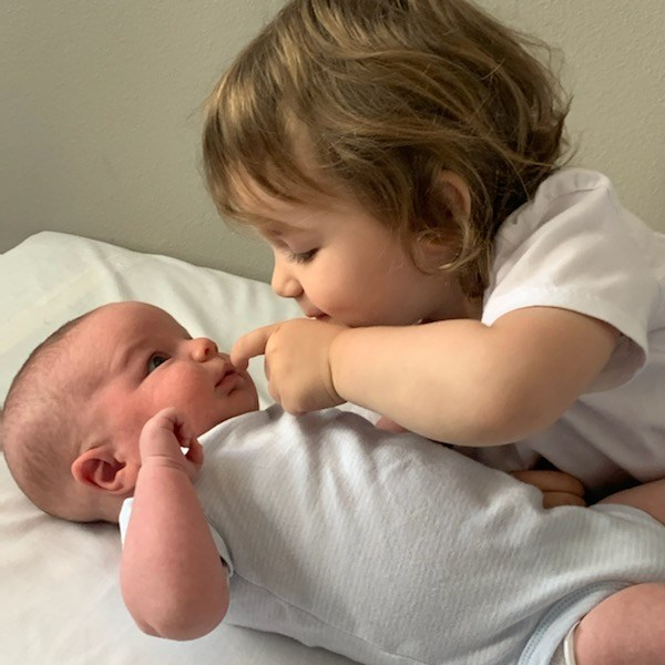 2 year old girl playing with newborn boy